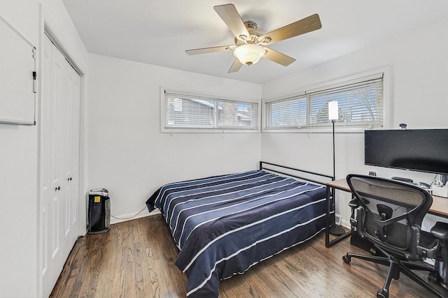 bedroom with dark hardwood / wood-style flooring, ceiling fan, and a closet