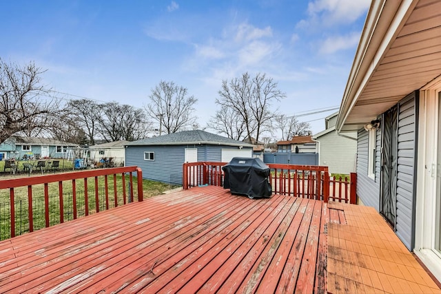 wooden terrace with an outbuilding, a yard, and grilling area