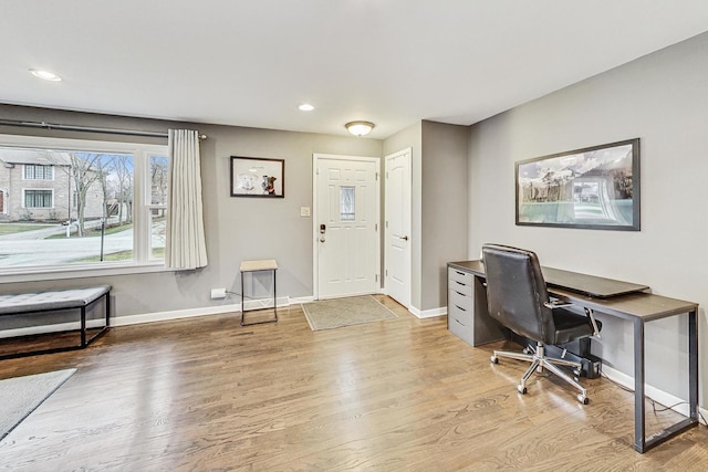 home office with light hardwood / wood-style flooring