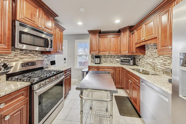 kitchen featuring decorative backsplash, appliances with stainless steel finishes, light stone counters, sink, and light tile patterned floors