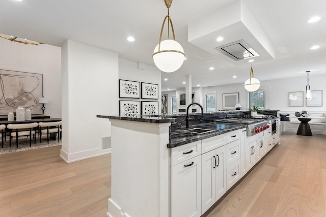 kitchen featuring a large island, light hardwood / wood-style floors, sink, and hanging light fixtures