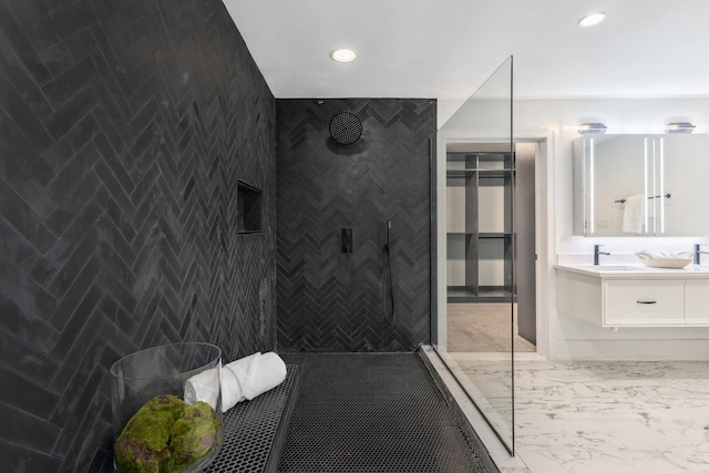 bathroom with vanity, walk in shower, and tile walls