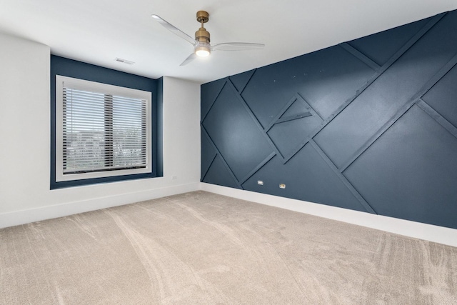 carpeted spare room featuring ceiling fan