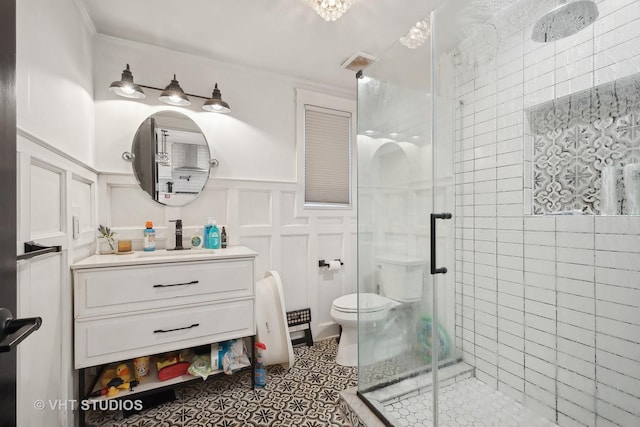 bathroom with tile patterned floors, vanity, a shower with shower door, and ornamental molding