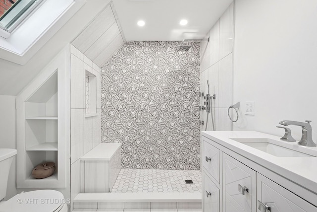 bathroom featuring vanity, toilet, built in features, and a tile shower