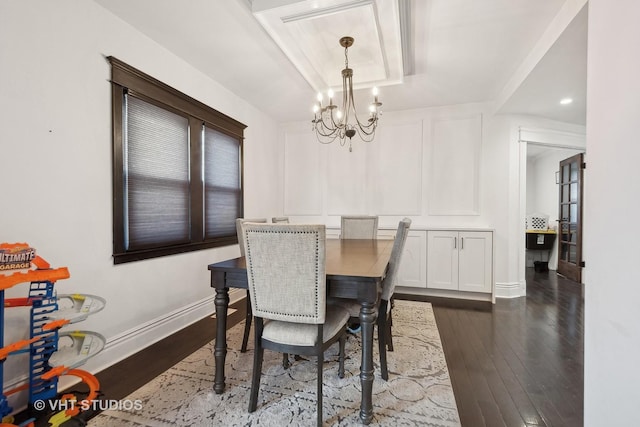 dining space with dark hardwood / wood-style flooring and a notable chandelier