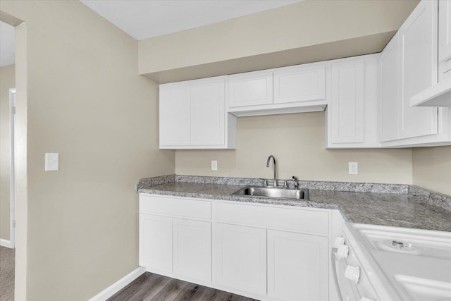 kitchen with white range oven, white cabinetry, sink, and dark hardwood / wood-style floors