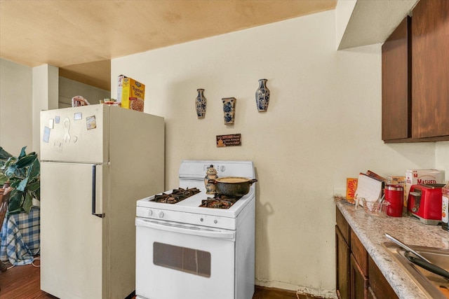 kitchen with hardwood / wood-style floors and white appliances