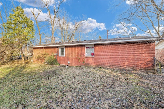 rear view of property featuring a lawn