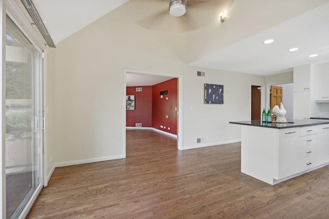 kitchen with ceiling fan, dark wood-type flooring, white cabinetry, and lofted ceiling