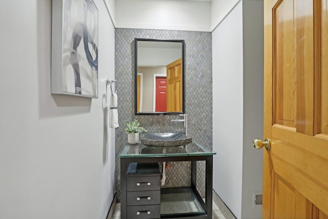 bathroom with sink and decorative backsplash