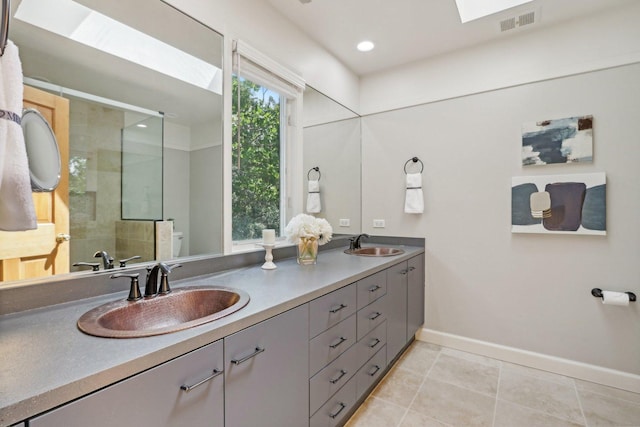 bathroom with a skylight, walk in shower, and vanity