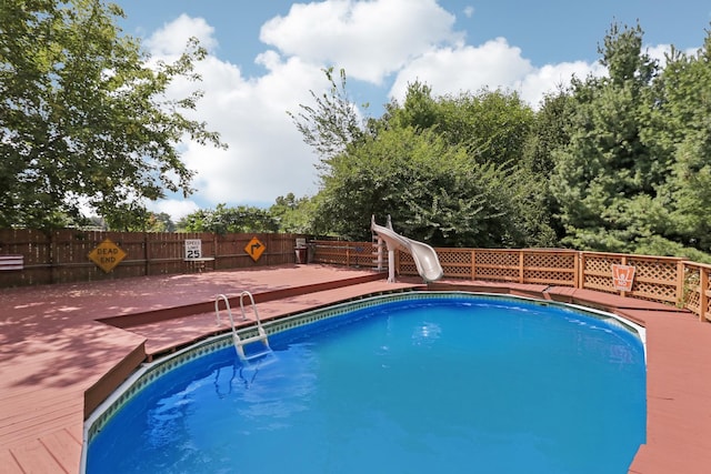 view of swimming pool with a deck and a water slide