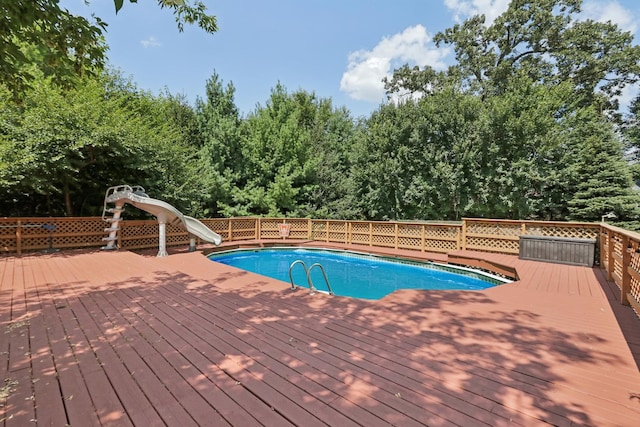 view of pool featuring a water slide and a wooden deck