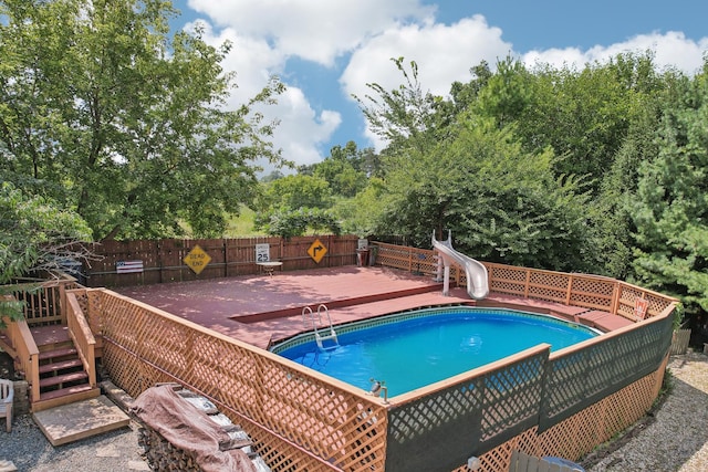 view of pool featuring a water slide and a wooden deck