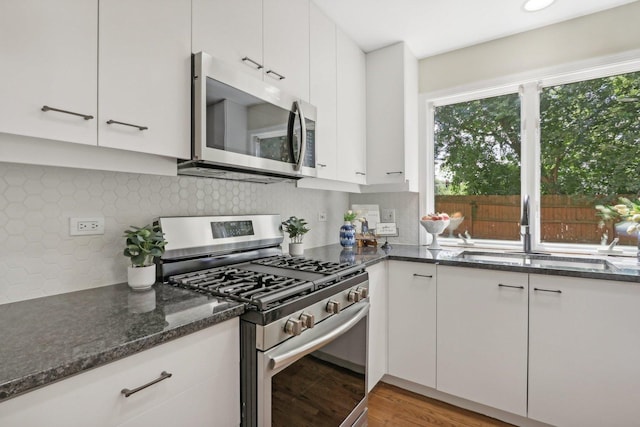 kitchen featuring sink, white cabinetry, backsplash, and appliances with stainless steel finishes