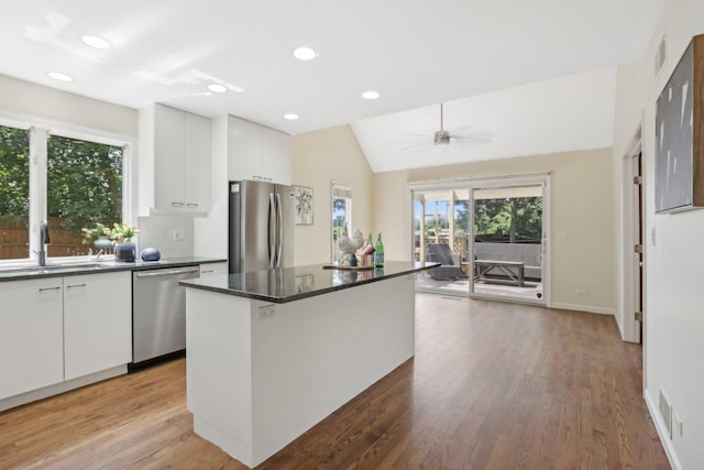 kitchen featuring appliances with stainless steel finishes, ceiling fan, a kitchen island, sink, and white cabinetry