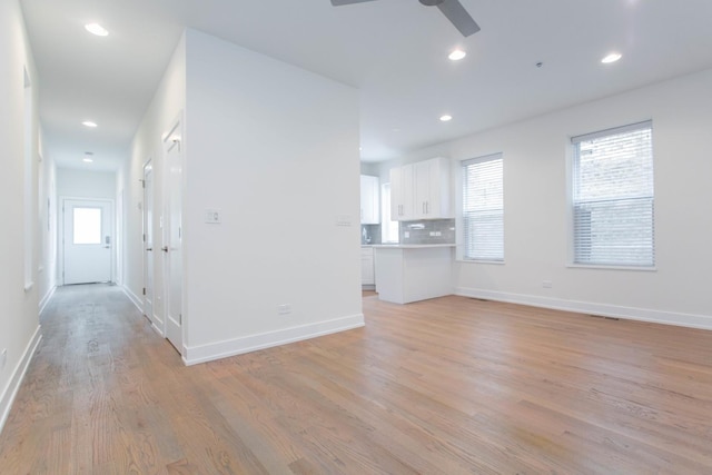 unfurnished living room featuring baseboards, ceiling fan, light wood-style flooring, and recessed lighting