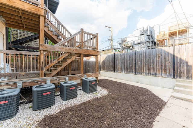 exterior space featuring central AC unit and fence