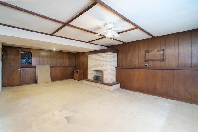 unfurnished living room with wood walls, ceiling fan, and a brick fireplace