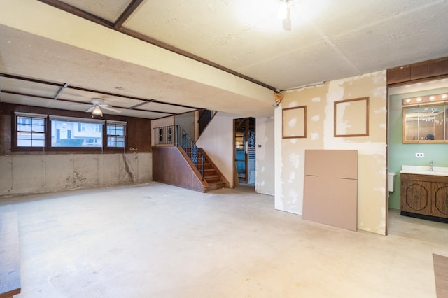 basement featuring ceiling fan and sink