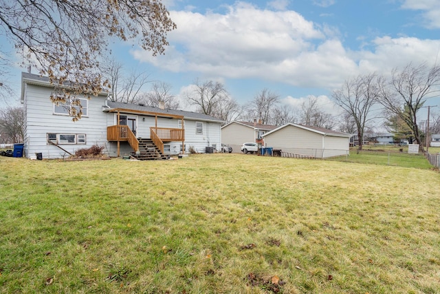 rear view of house with a lawn and a wooden deck