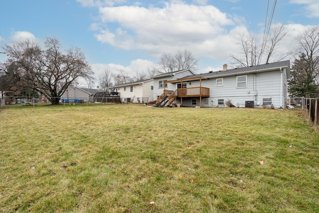 back of property with a lawn and a deck