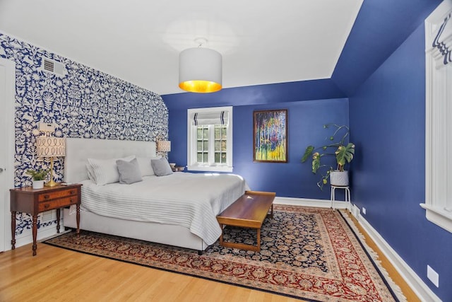 bedroom featuring wood-type flooring and vaulted ceiling