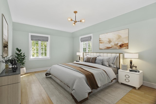 bedroom with light hardwood / wood-style floors and a chandelier