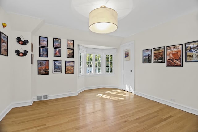 spare room with vaulted ceiling and light wood-type flooring