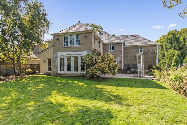 back of property featuring a lawn and a patio area