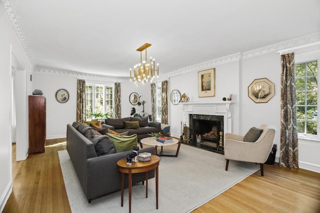 living room featuring ornamental molding, a fireplace, a chandelier, and hardwood / wood-style floors