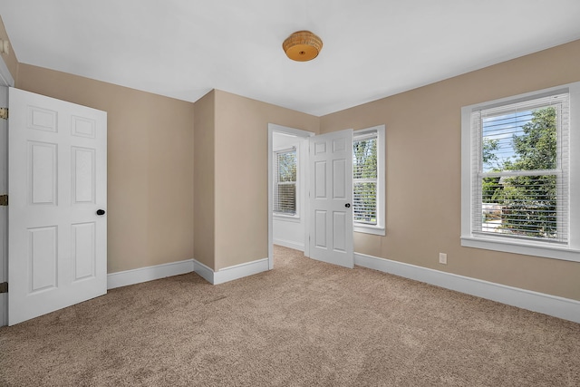 carpeted spare room featuring a wealth of natural light