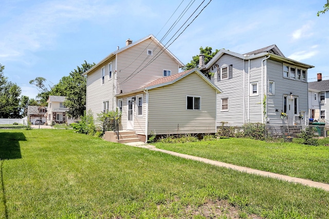 rear view of property featuring a lawn