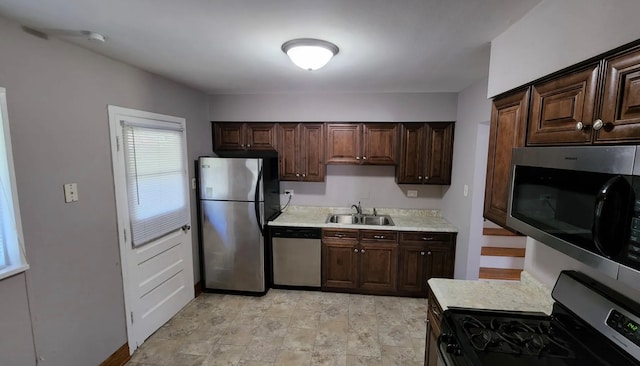 kitchen with dark brown cabinetry, stainless steel appliances, and sink