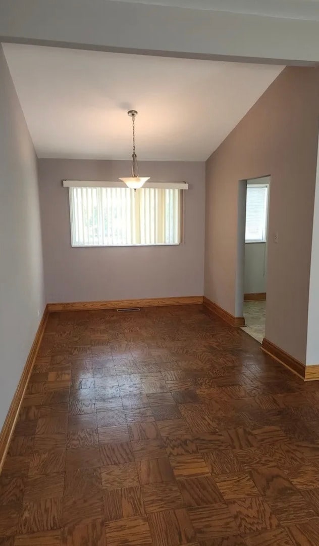 empty room with vaulted ceiling and a wealth of natural light