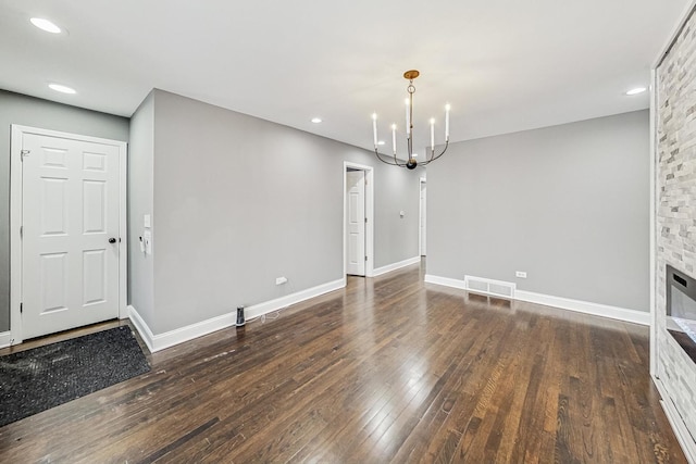 unfurnished dining area with dark hardwood / wood-style flooring and a notable chandelier