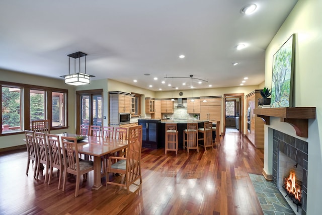 dining room featuring dark wood-type flooring and a tile fireplace