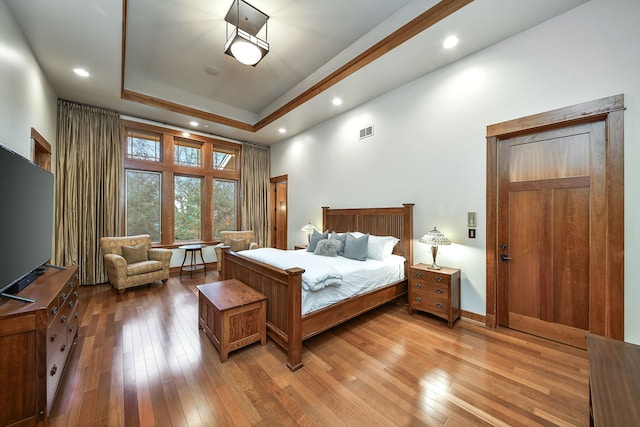 bedroom featuring wood-type flooring and a tray ceiling