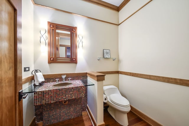 bathroom with ornamental molding, sink, hardwood / wood-style floors, and toilet