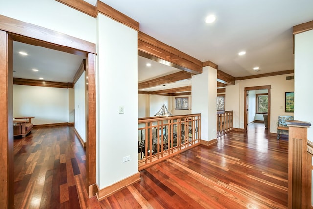 hall with dark wood-type flooring, ornamental molding, and beamed ceiling