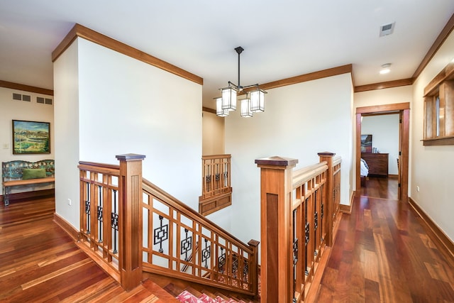 hallway featuring ornamental molding, dark hardwood / wood-style floors, and a chandelier