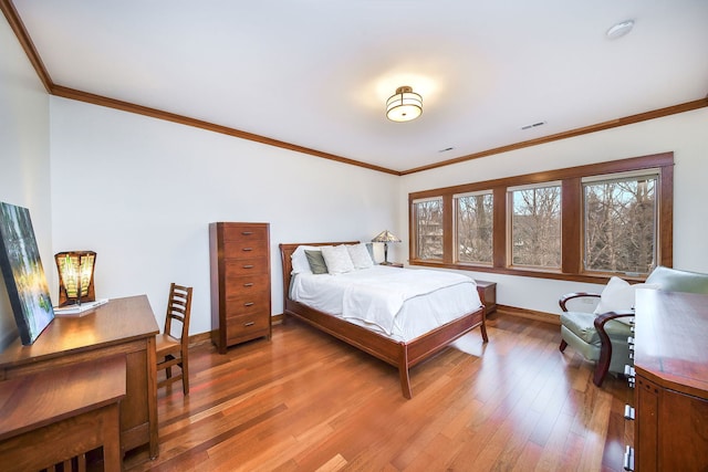 bedroom with crown molding and hardwood / wood-style floors