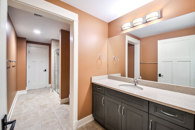 bathroom with vanity and a shower with door