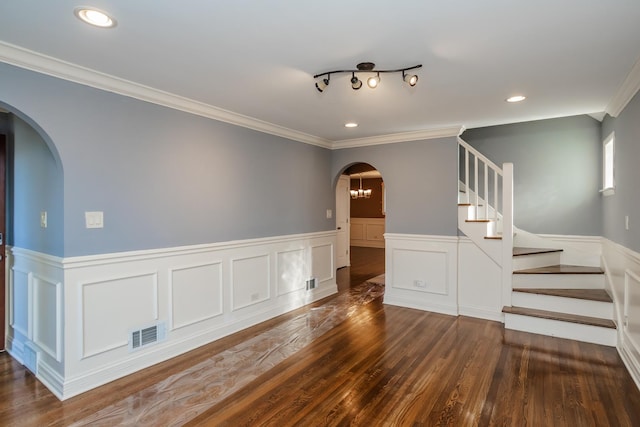 spare room featuring crown molding and dark hardwood / wood-style flooring