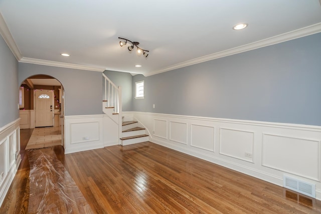 empty room with crown molding and hardwood / wood-style floors