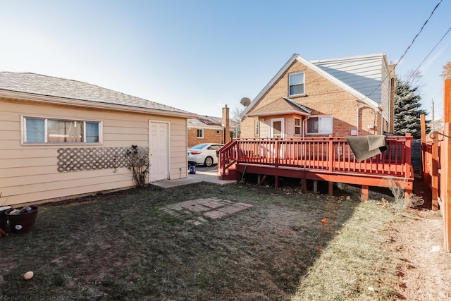 rear view of house with a yard and a deck