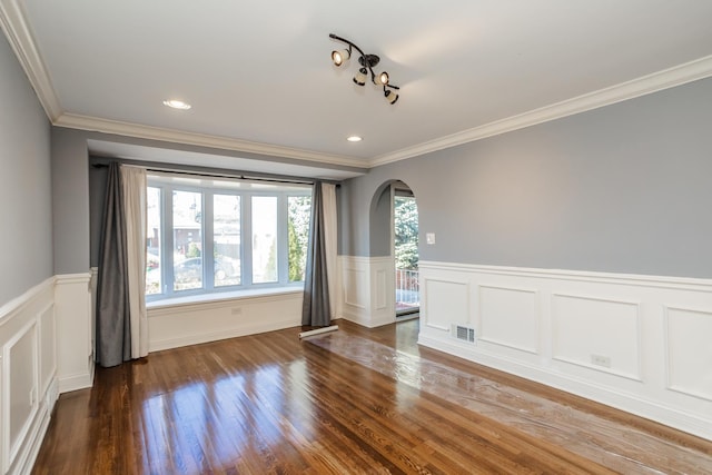 empty room featuring dark hardwood / wood-style flooring, a wealth of natural light, and crown molding