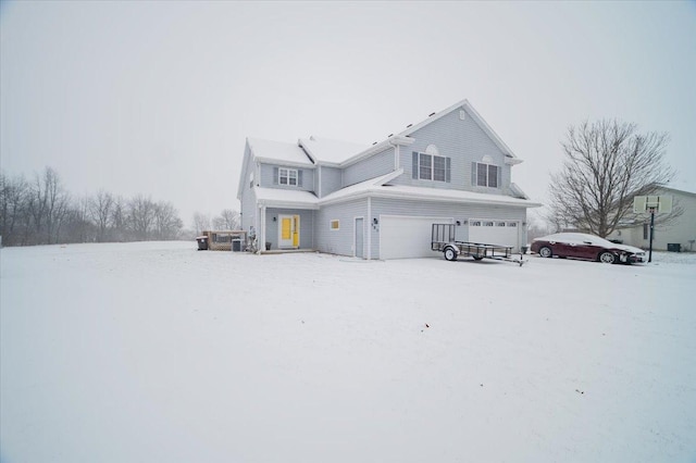 snow covered rear of property featuring a garage