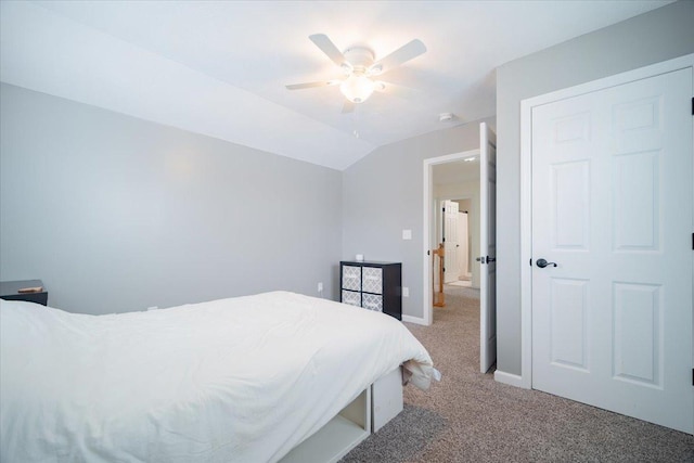 bedroom featuring vaulted ceiling, light colored carpet, and ceiling fan